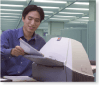 Man in office retrieving pages from a printer
