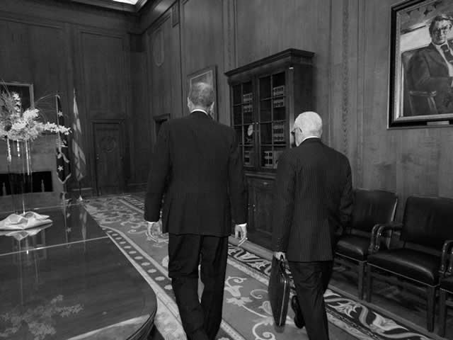Attorney General Holder and former Attorney General Mukasey, walking.