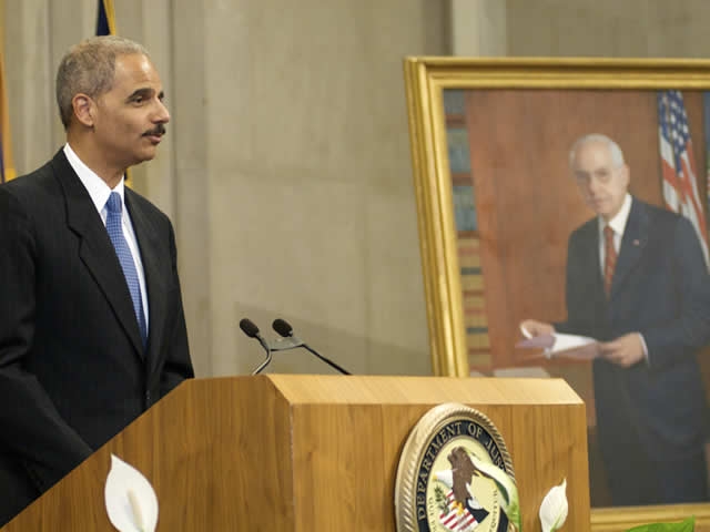 Attorney General Holder speaks next to the portrait.