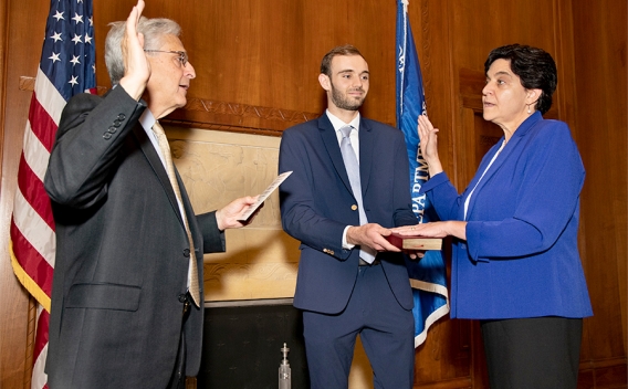 Attorney General Merrick B. Garland swears in Rosie Hidalgo as the new Director of the Office on Violence Against Women. Rosie Hidalgo swears on the bible while raising her hand