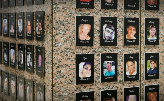 At the DEA Museum in Washington, D.C. a permanent memorial displays the faces of lives lost due to fentanyl overdose. Many individual portrait photos in black frames show the names and ages of victims.