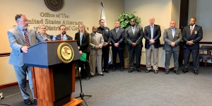 Law enforcement officials stand in front of U.S. Attorney seal for news conference