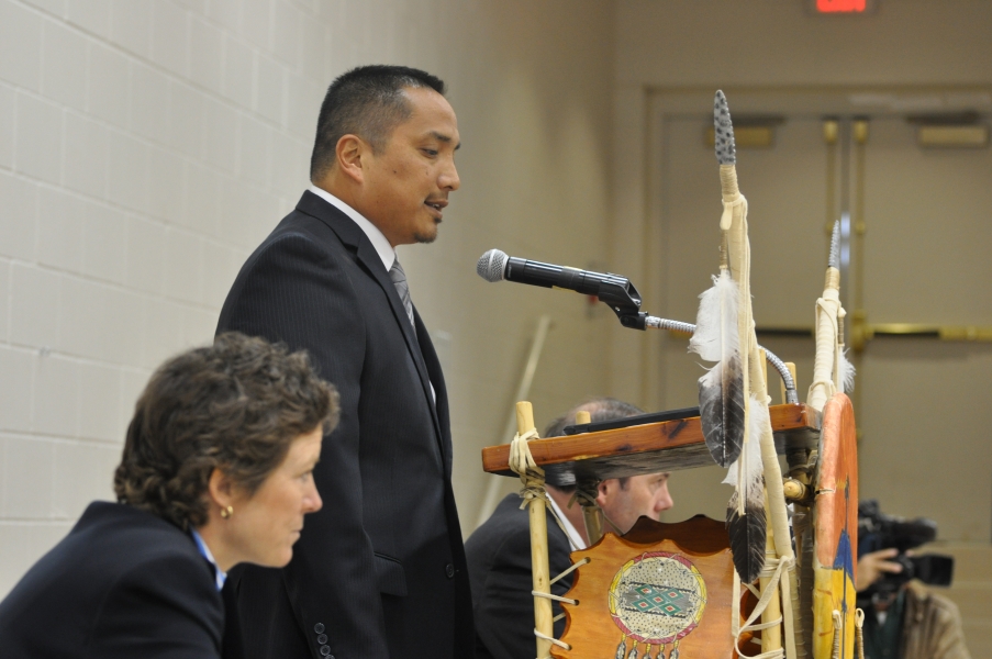 Bureau of Indian Affairs Special Agent in Charge Mario Red Legs speaks to the 2nd Annual U.S. Attorney's Tribal Consultation Conference. Seated at table are Jennifer Keenan, FBI-Minneapolis Division Assistant Special Agent in Charge and U.S. Attorney Tim Purdon. Bureau of Indian Affairs Special Agent in Charge Mario Red Legs speaks.