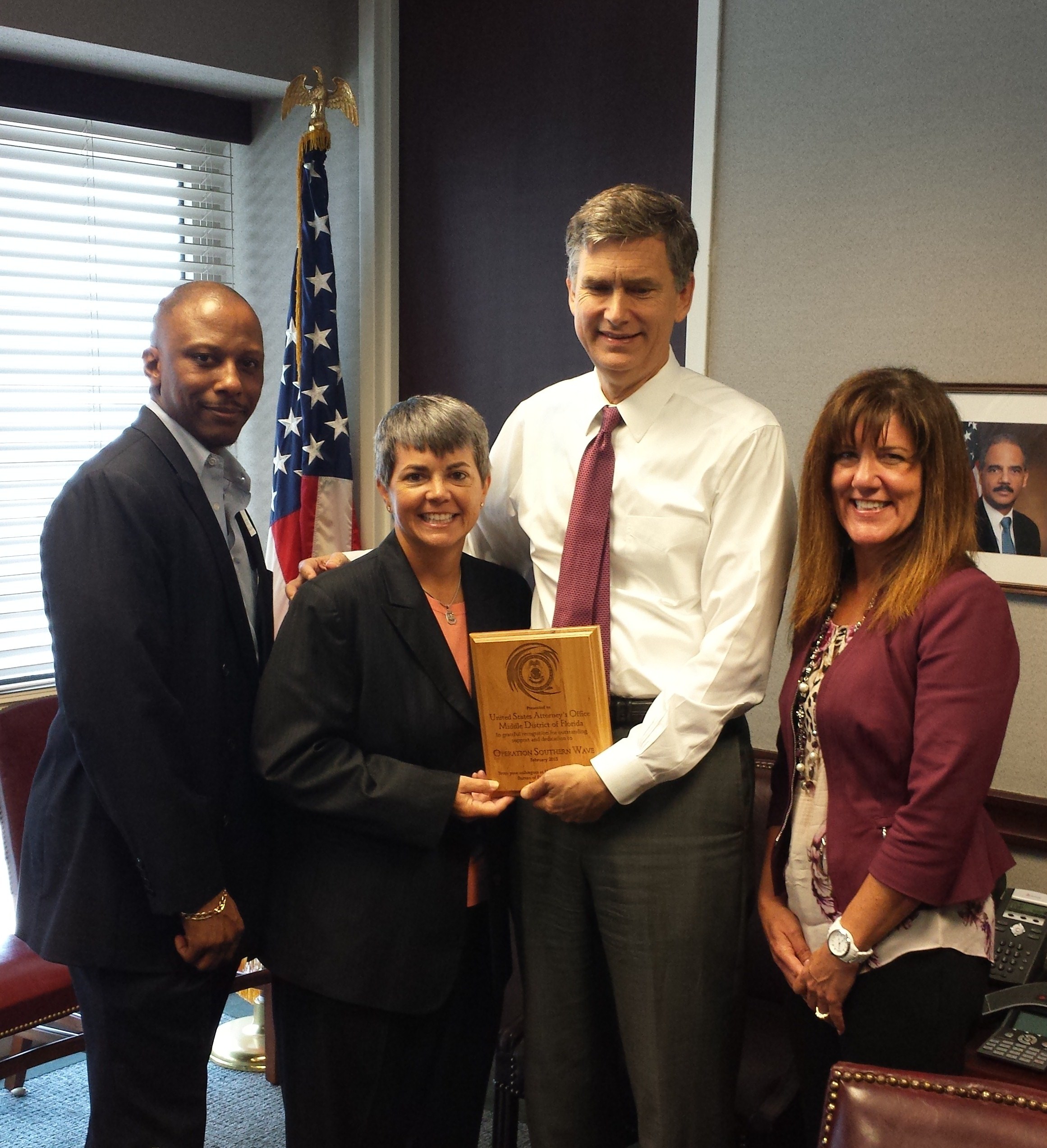 Pictured: U.S. Attorney Lee Bentley is presented with an award