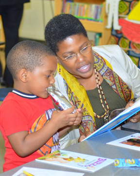 Debra Matthews, Human Resource Officer, reading to a student at Bethune Elementary School