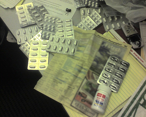 Photo of packages of pseudoephedrine, pharmacy listings torn from a telephone directory, and cellular telephones.