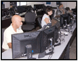 Man and woman in front of computers in WildBlue network operations center