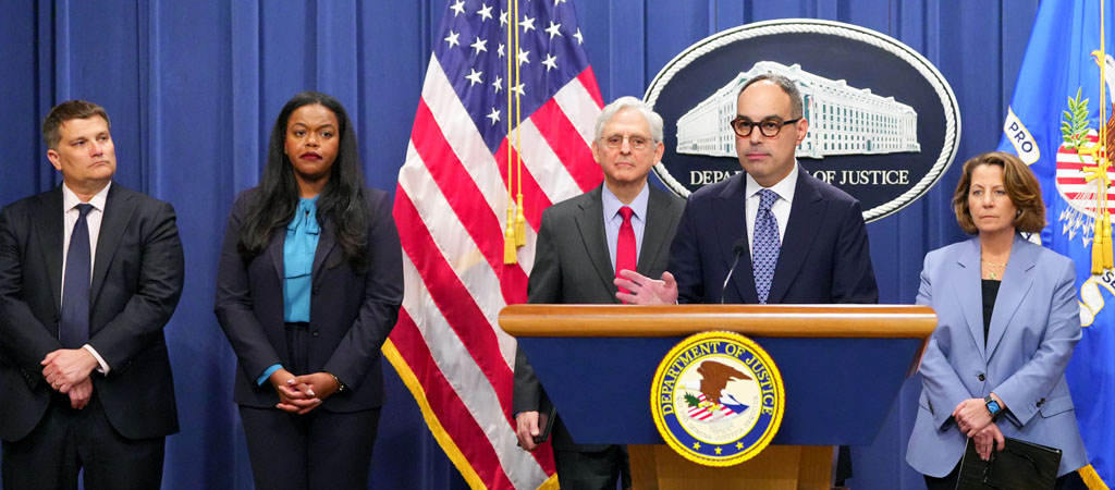 Assistant Attorney General Jonathan Kanter speaking at a Department of Justice podium with Deputy Assistant Attorney General Andrew Forman, Principal Deputy Assistant Attorney General Doha Mekki, Attorney General Merrick Garland, and Deputy Attorney General Lisa Monaco (standing from left to right). 