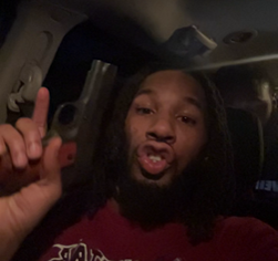 Image of man holding pistol in a car