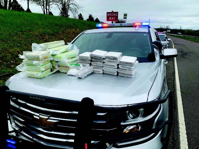 15 kilograms of powdered fentanyl, 24.4 kilograms of methamphetamine, .6 kilograms of heroin, and 4.6 kilograms of cocaine on hood of police car.