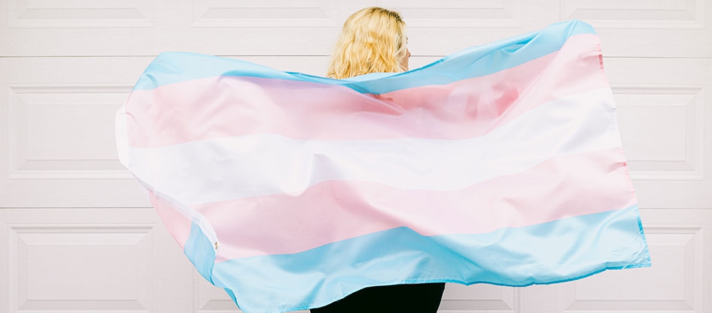 An image of a transgender individual wearing the transgender flag