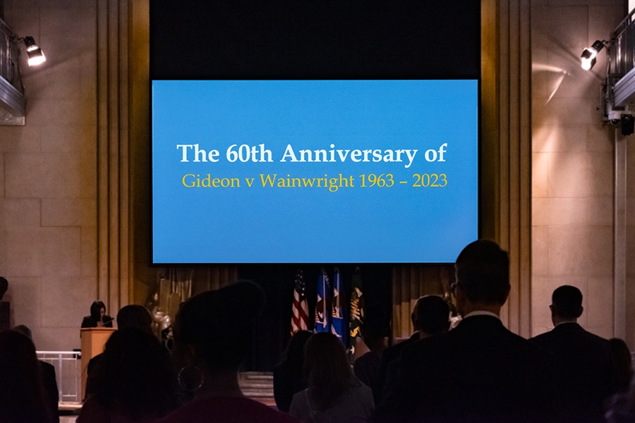 The Great Hall in Washington, D.C. displays a large screen with words “The 60th Anniversary of Gideon v Wainwright 1963-2023”