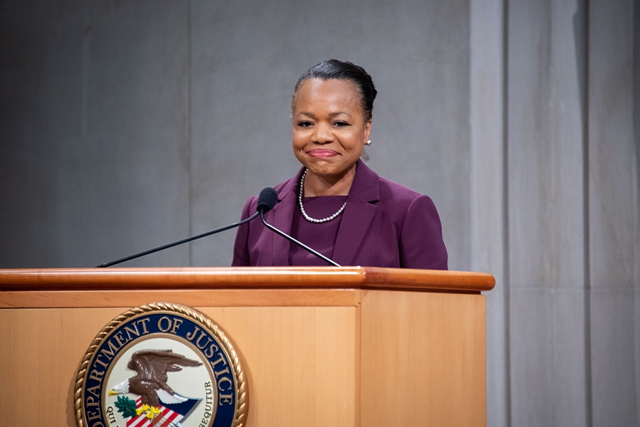 Assistant Attorney General for Civil Rights Kristen Clarke delivers remarks from a podium in the Great Hall at the Department of Justice.