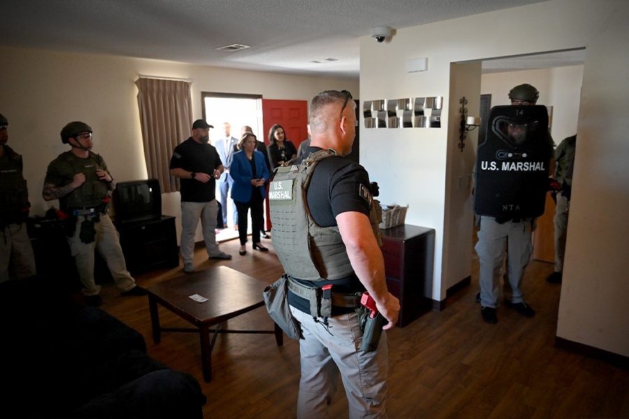 Deputy Attorney General Lisa O. Monaco observes tactical exercises lead by Deputy U.S. marshals inside a residential home.