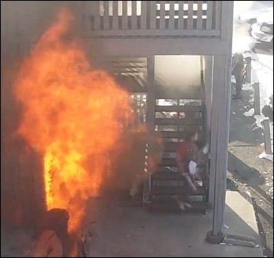 Apartment building on fire as people leave the building.