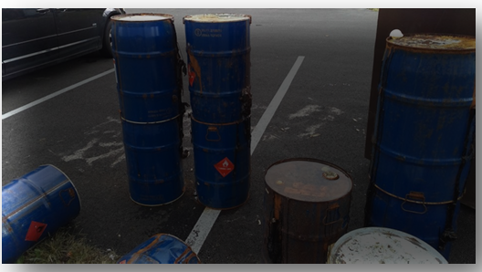 Leaking drums abandoned in parking lot