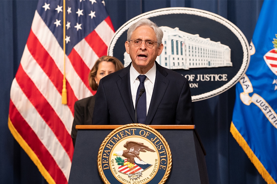 Attorney General Merrick B. Garland delivers remarks from a podium at the Department of Justice.