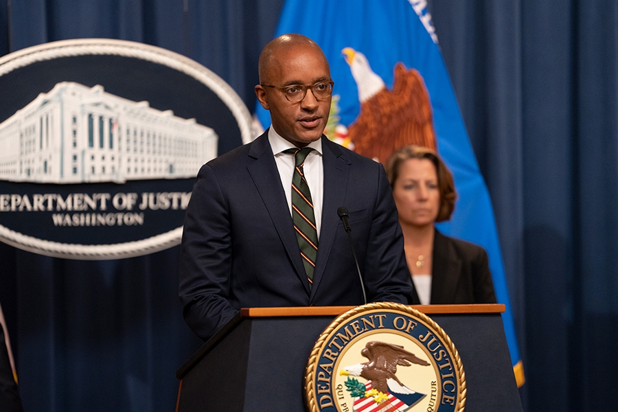 U.S. Attorney Damian Williams for the Southern District of New York delivers remarks from a podium at the Department of Justice.