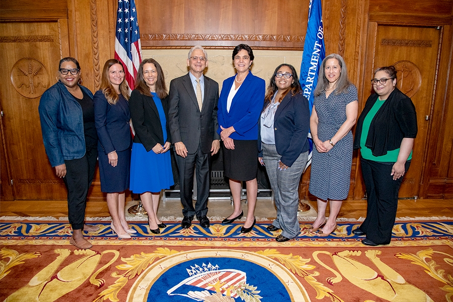 Attorney General Merrick B. Garland and OVW Director Rosie Hidalgo (center) stand with attendees at the swear in ceremony in the Attorney General’s conference room at the Department of Justice