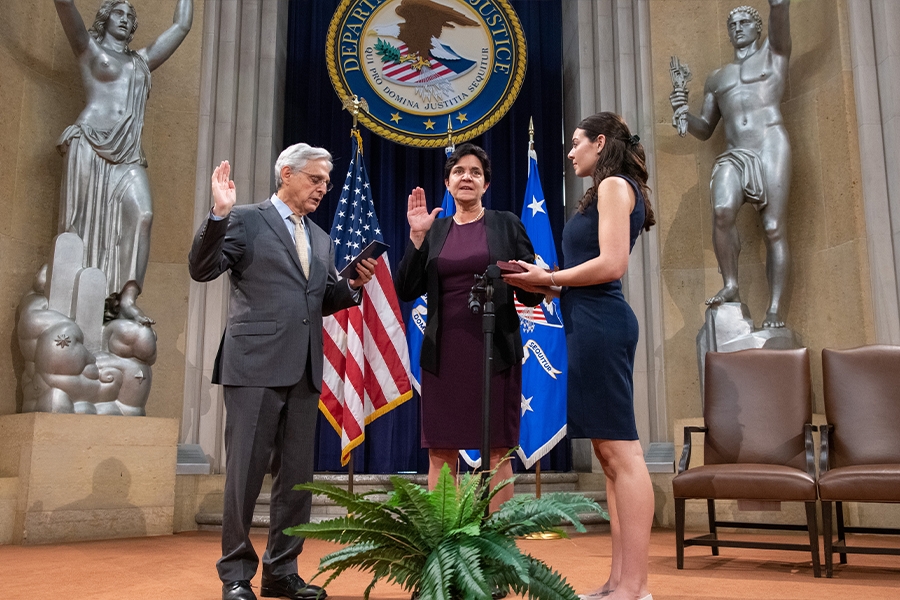 Attorney General Merrick B. Garland swears in Rosie Hidalgo as the new Director of the Office on Violence Against Women. Rosie Hidalgo swears on the bible while raising her hand