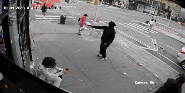 Photo of the defendant firing a gun