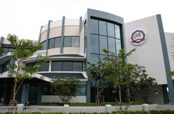 Front of a the modern, curving glass and concrete main facilities of the International Law Enforcement Agency of Bangkok