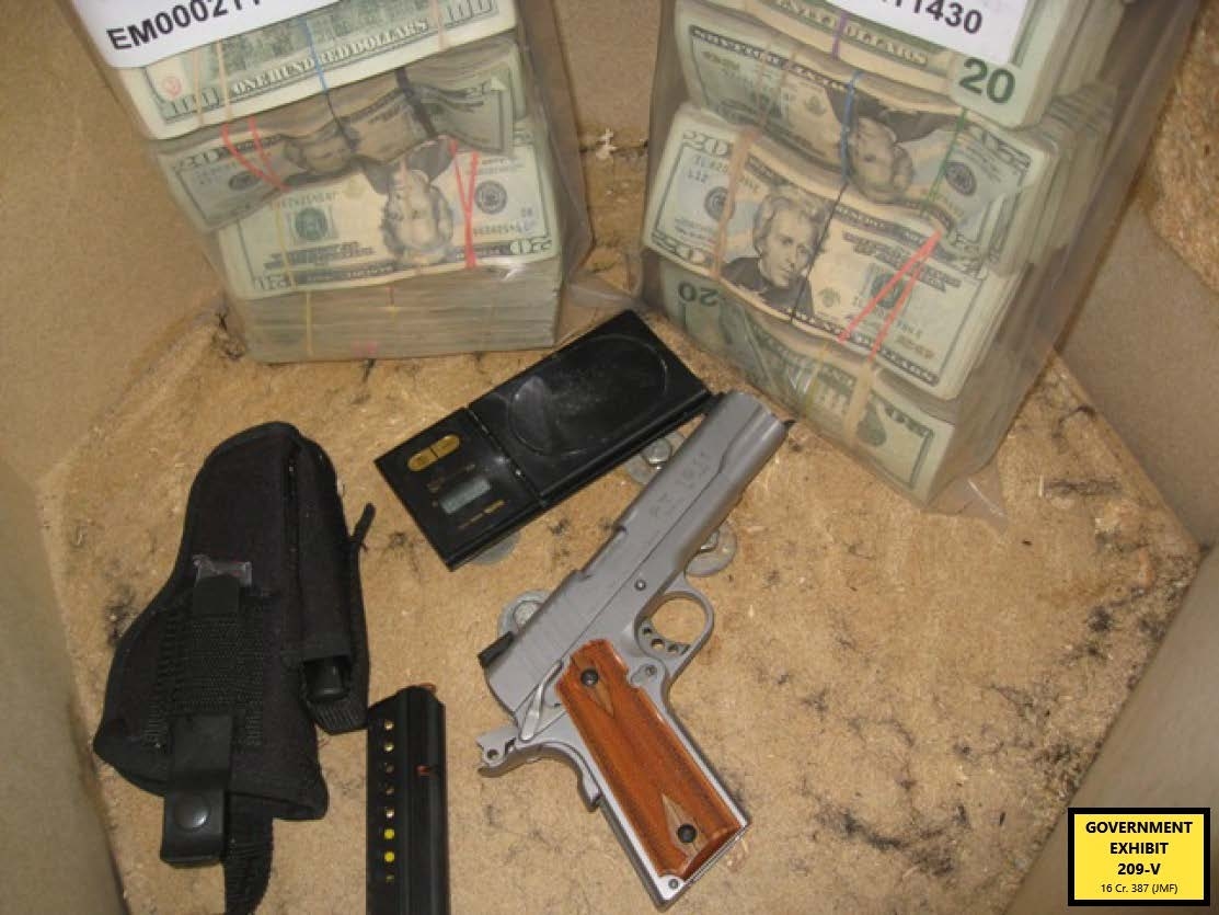 Photo of bags of cash, a gun and a scale