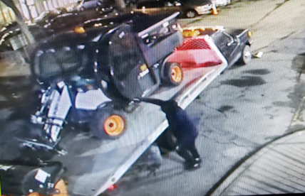 Photo showing the defendant using large trucks to steal utility vehicles