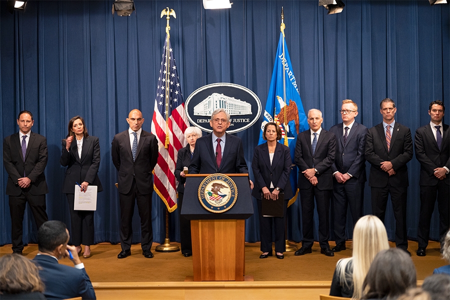 Attorney General Merrick B. Garland delivers remarks from a podium at the Department of Justice. He is joined by Department of Justice and federal government officials.