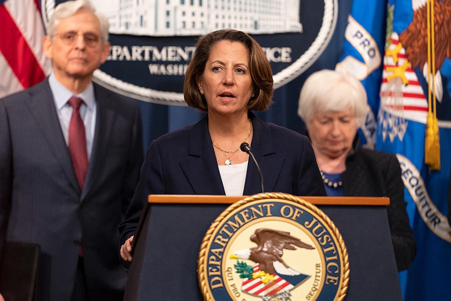 Deputy Attorney General Lisa O. Monaco delivers remarks from a podium at the Department of Justice. To the left is Attorney General Merrick B. Garland, and to the right is Secretary of the Treasury Janet L. Yellen.