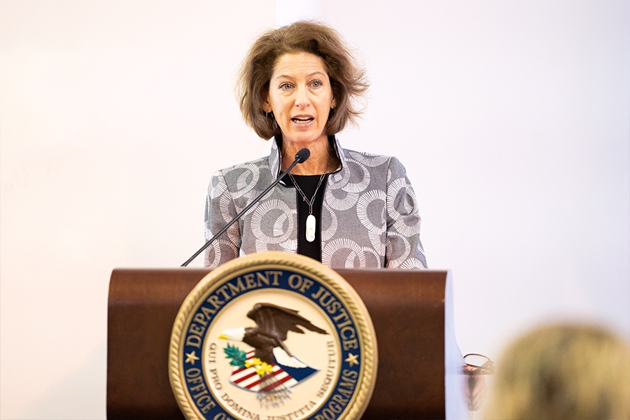 Assistant Attorney General for the Office of Justice Programs Amy Solomon delivers remarks from a podium at the Office of Justice Programs.