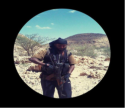 Photo of the defendant carrying an AK-47 assault rifle