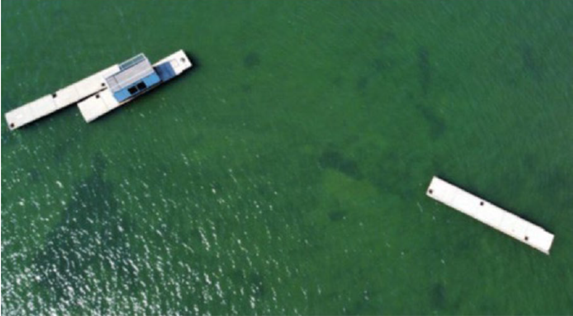 Two docks float on green, clear water