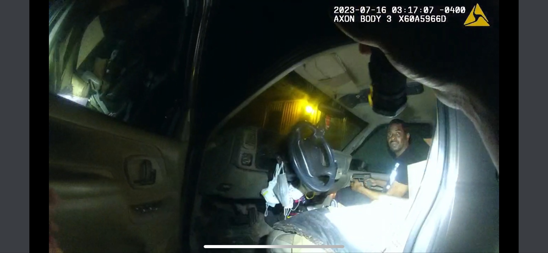 Man sitting in vehicle with gun in hand