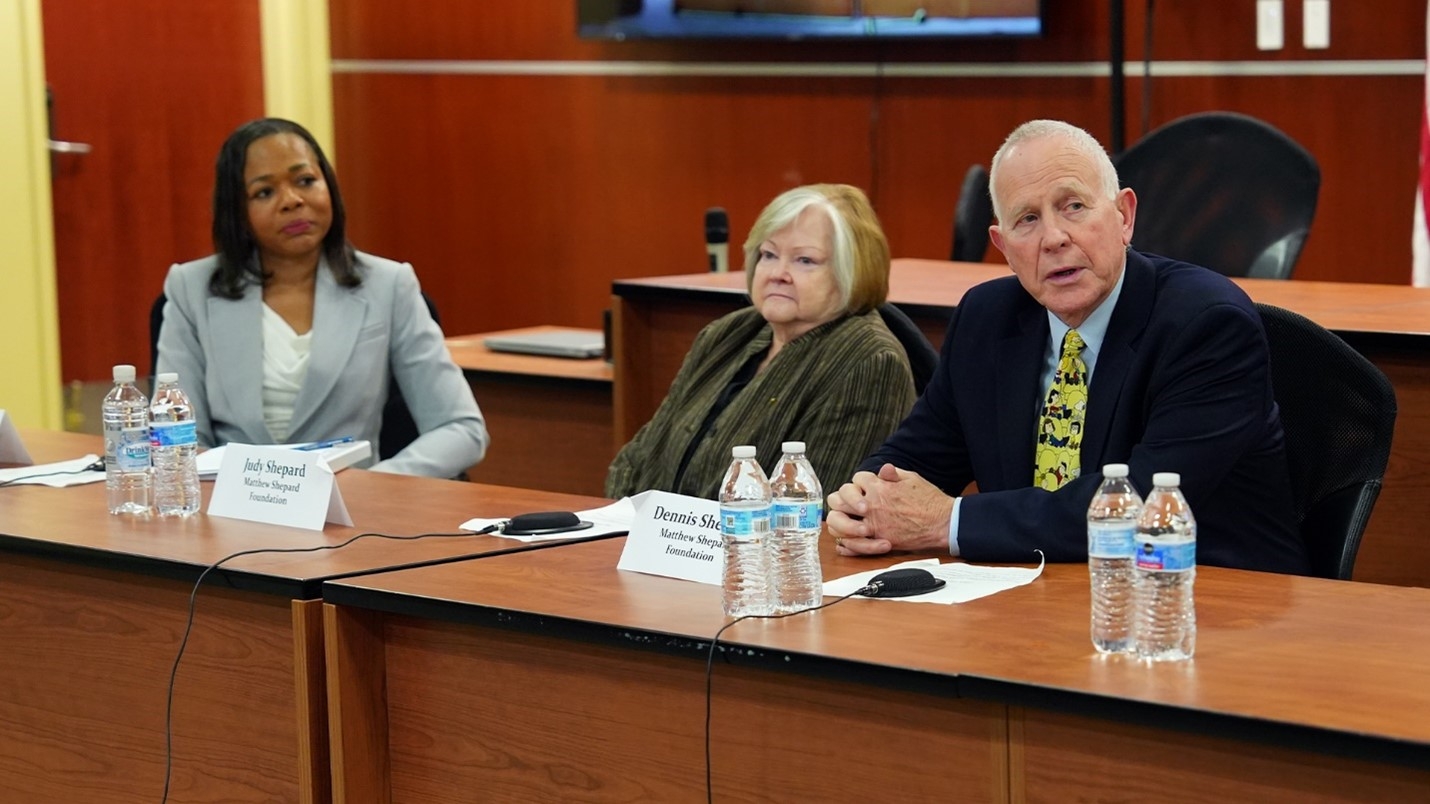 Assistant Attorney General Clarke sits with Judy and Dennis Shepard, Matthew Shepard’s parents.