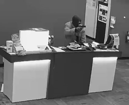 Surveillance still shot of man pointing gun