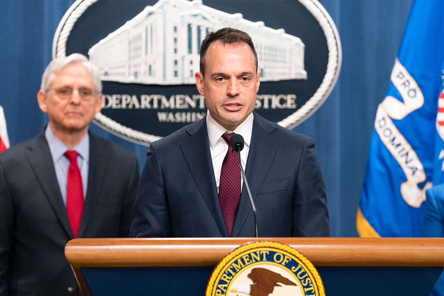 Acting Associate Attorney General Benjamin C. Mizer delivers remarks from a podium at the Department of Justice. He is joined by Department of Justice and federal government officials.