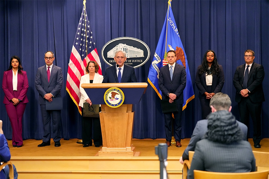 Attorney General Merrick B. Garland delivers remarks from a podium at the Department of Justice. He is joined by Department of Justice and federal government officials.