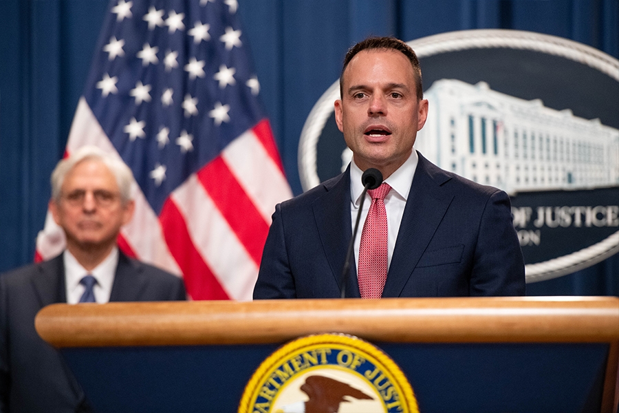 Principal Deputy Associate Attorney General Benjamin C. Mizer delivers remarks from a podium at the Department of Justice. He is joined by Department of Justice and federal government officials.