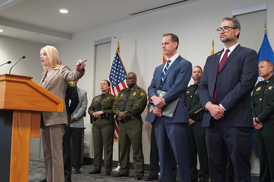 Attorney General Pamela Bondi delivers remarks from a podium at the Broward County Sheriff's Office. She is joined by Broward County Sheriffs and federal government officials.