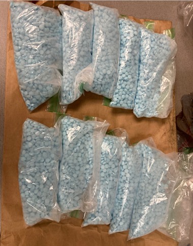 Image of several bags containing blue counterfeit fentanyl-laced pills seized from Lonnie Laronn Marrow in Kalamazoo