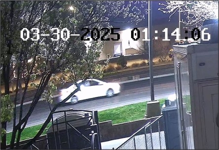 A white car driving down the street.