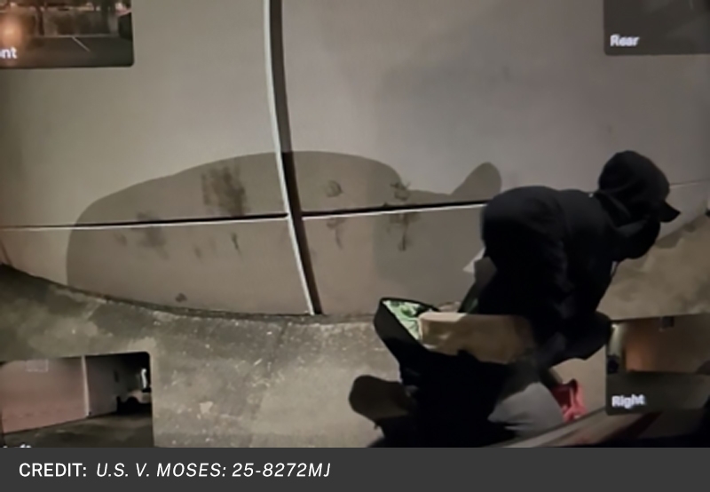 Image of suspect pulling fire starter log from backpack.