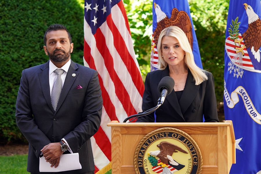Attorney General Pamela Bondi delivers remarks from a podium at the Department of Justice. She is joined by FBI Director Kash Patel.