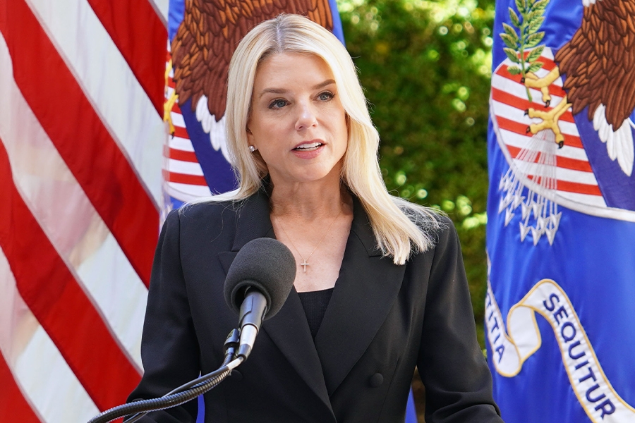 Attorney General Pamela Bondi delivers remarks from a podium at the Department of Justice.
