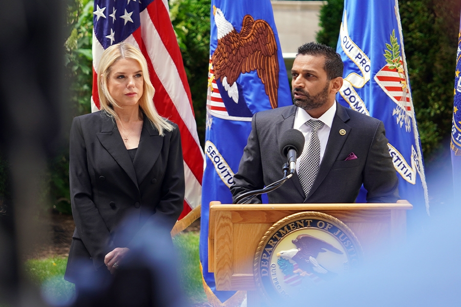 FBI Director Kash Patel delivers remarks from a podium at the Department of Justice. He is joined by Attorney General Pamela Bondi.