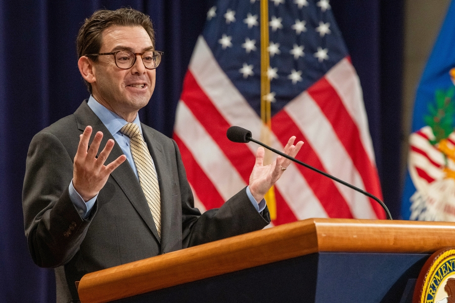 Chair of the Federal Interagency Holocaust Remembrance Committee Brant Levine delivers remarks from a podium in the Great Hall at the Department of Justice.