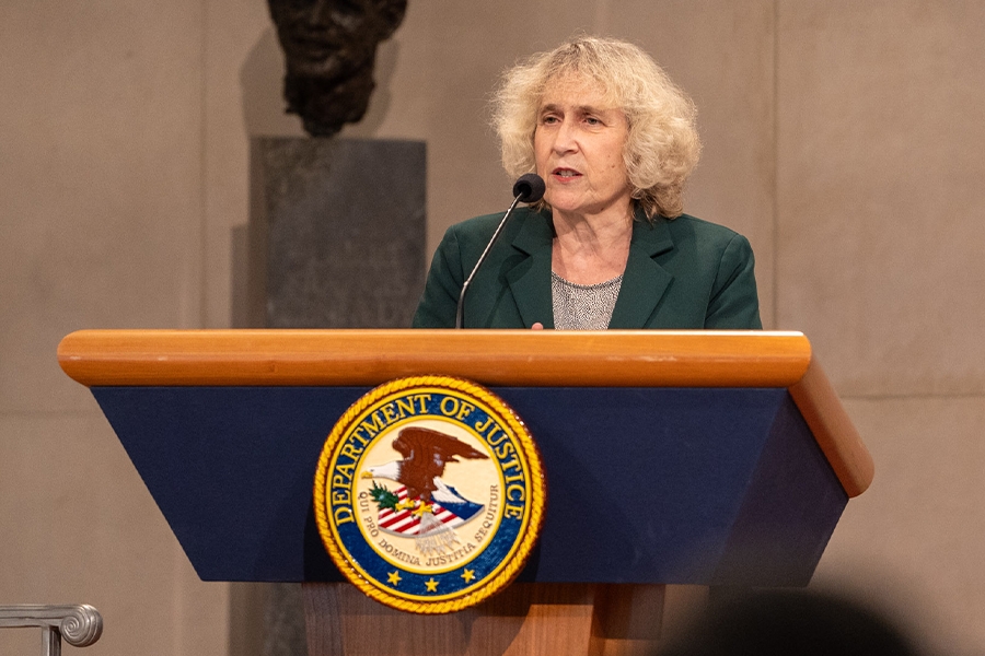 Special Envoy for Holocaust Issues Department of State Ellen Germain delivers remarks from a podium in the Great Hall at the Department of Justice.