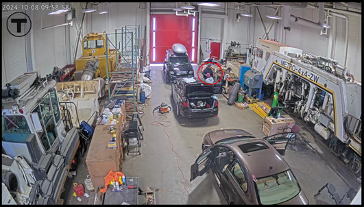Gamble (circled in red below) performing detail work on a private vehicle inside of Cabot Garage