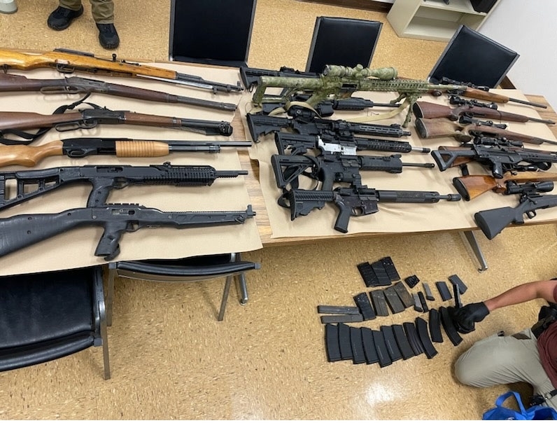 photo of guns on tables and ammunition on the floor